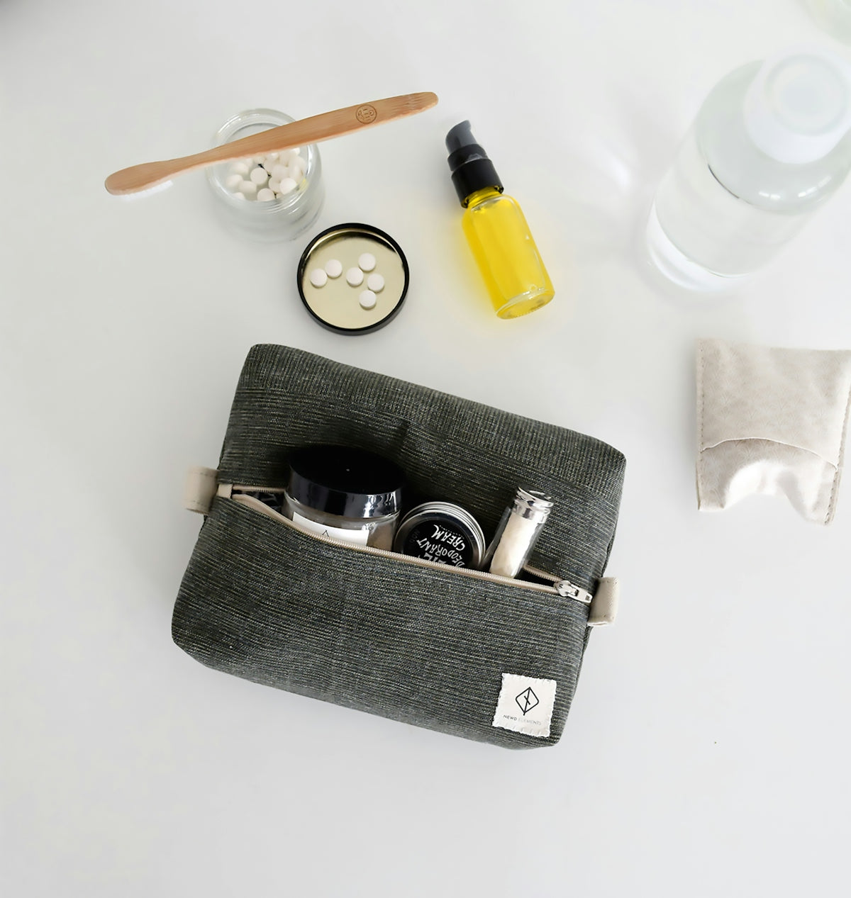 Gray toiletry bag with travel-sized cosmetics and full-sized products