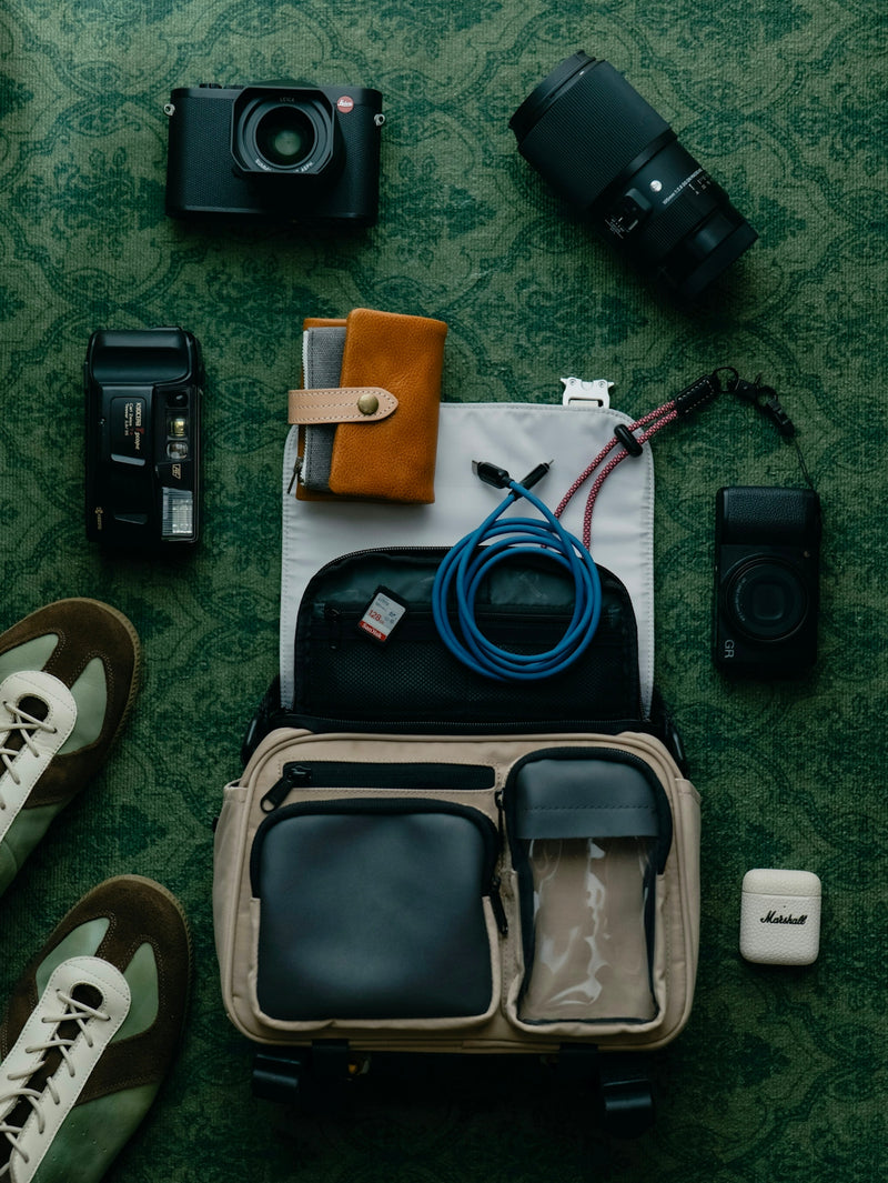 Camera gear and accessories laid out on a patterned surface