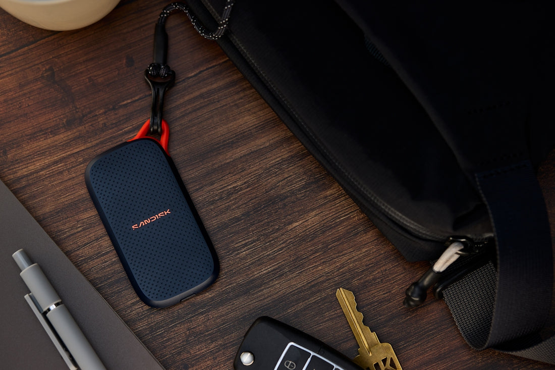 Portable ssd, keys, and pen next to a black bag